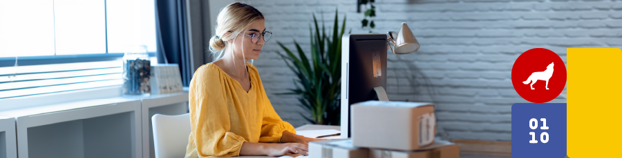 Person working at a desk with two monitors, a laptop, and NJIT logo in an office.

